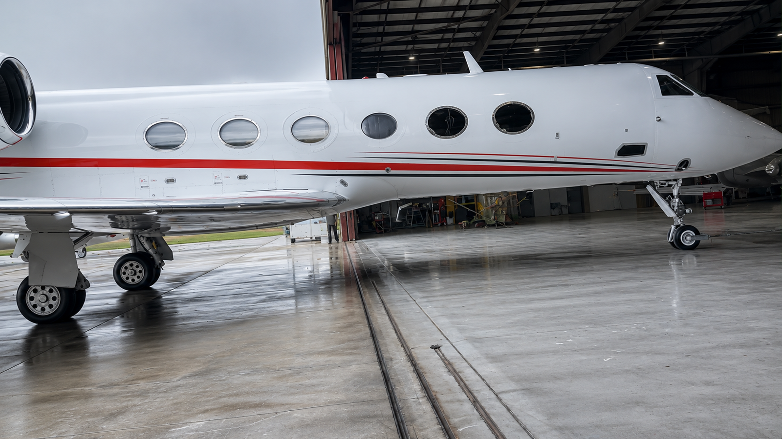 Aircraft before painting, showing the original worn red and black striped livery